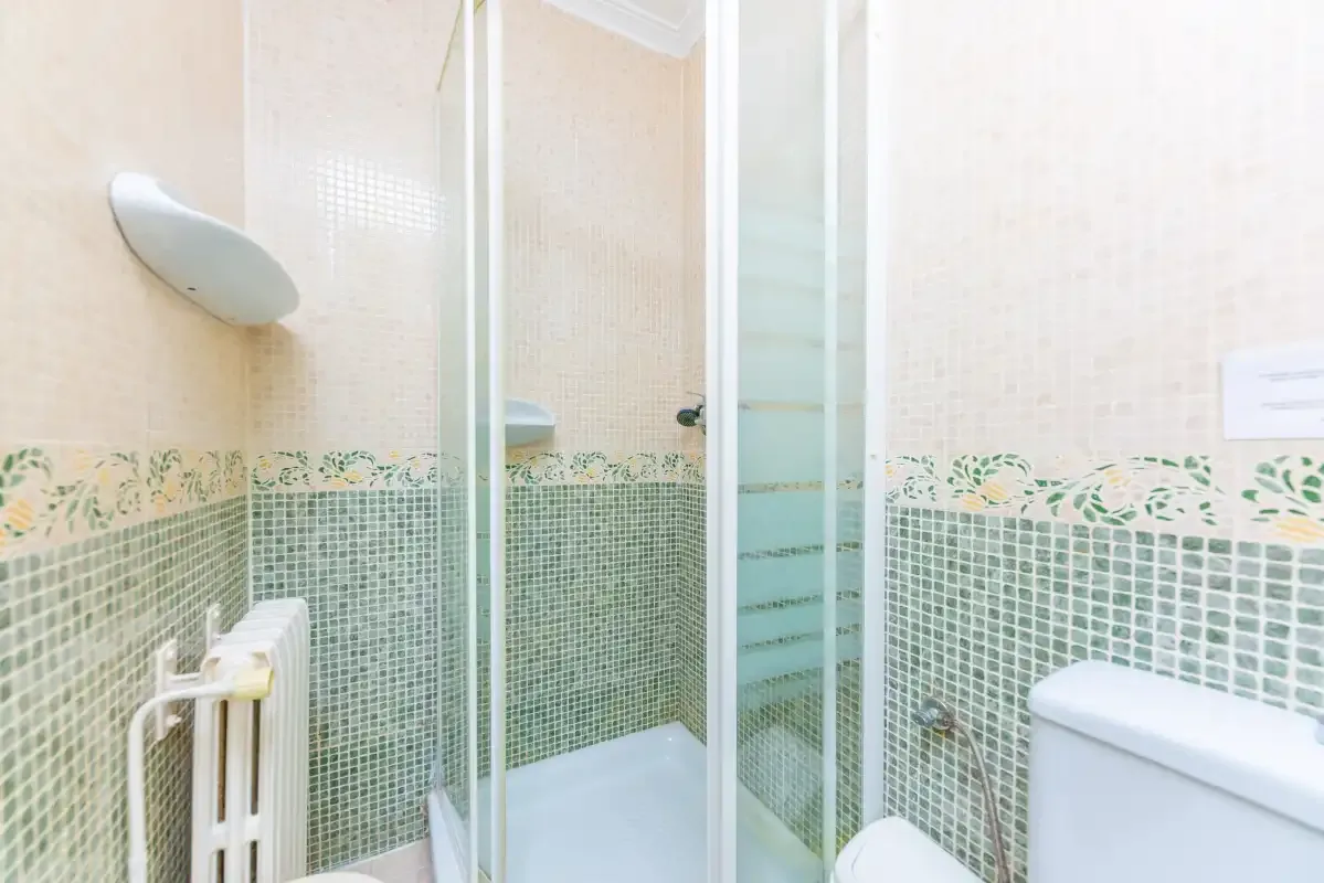 A tiled bathroom with a glass-enclosed shower.