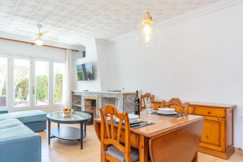 A bright dining and living area with wooden seating and a round coffee table.