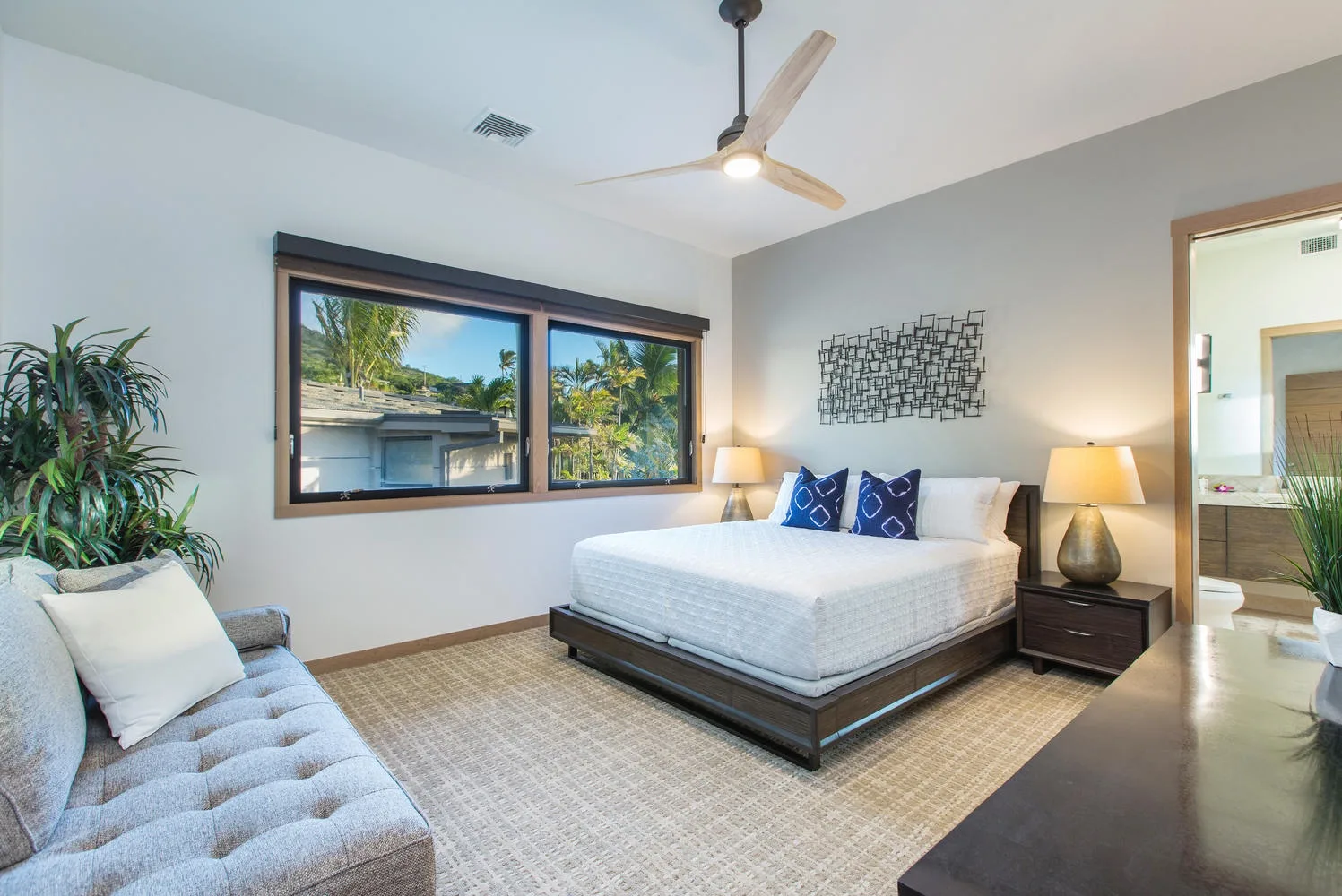 A bedroom with a bed, a window, and a ceiling fan.
