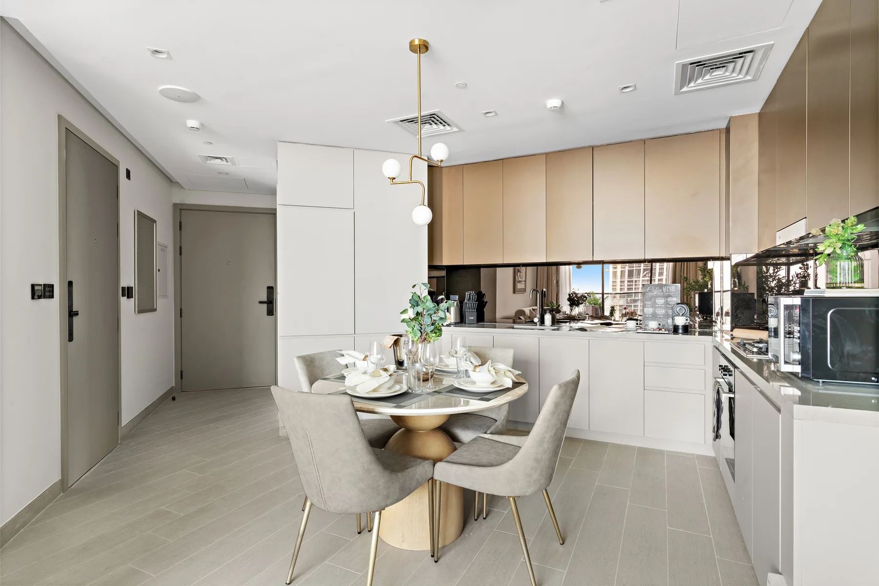 A modern kitchen and dining area with a set table and built-in appliances.