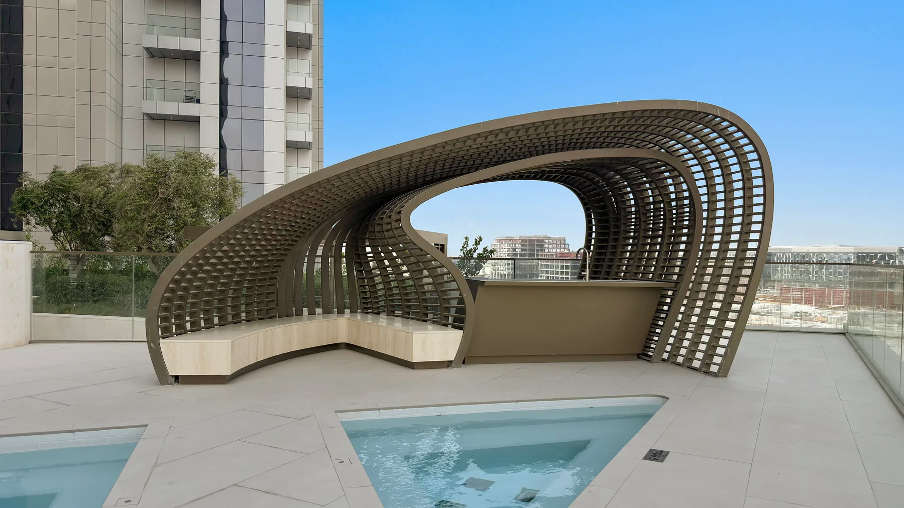 A rooftop terrace features an oval sculptural canopy beside a swimming pool.