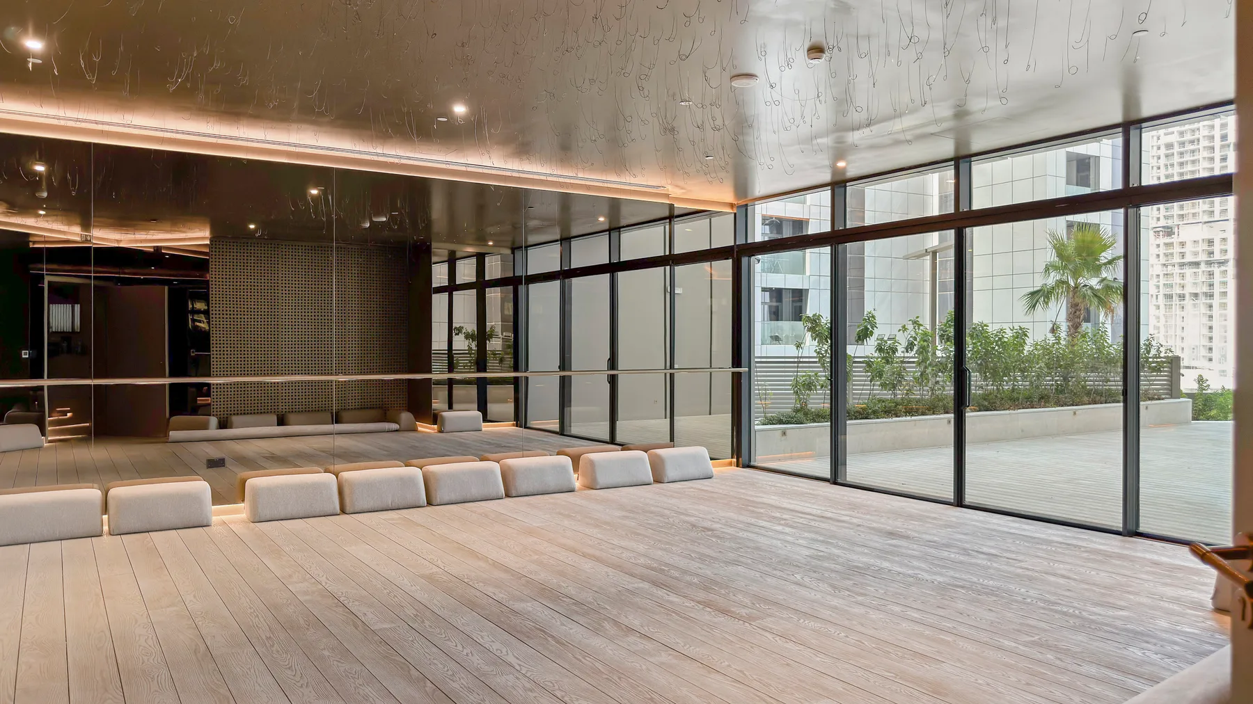 A spacious indoor lounge opens onto a terrace through floor-to-ceiling windows.