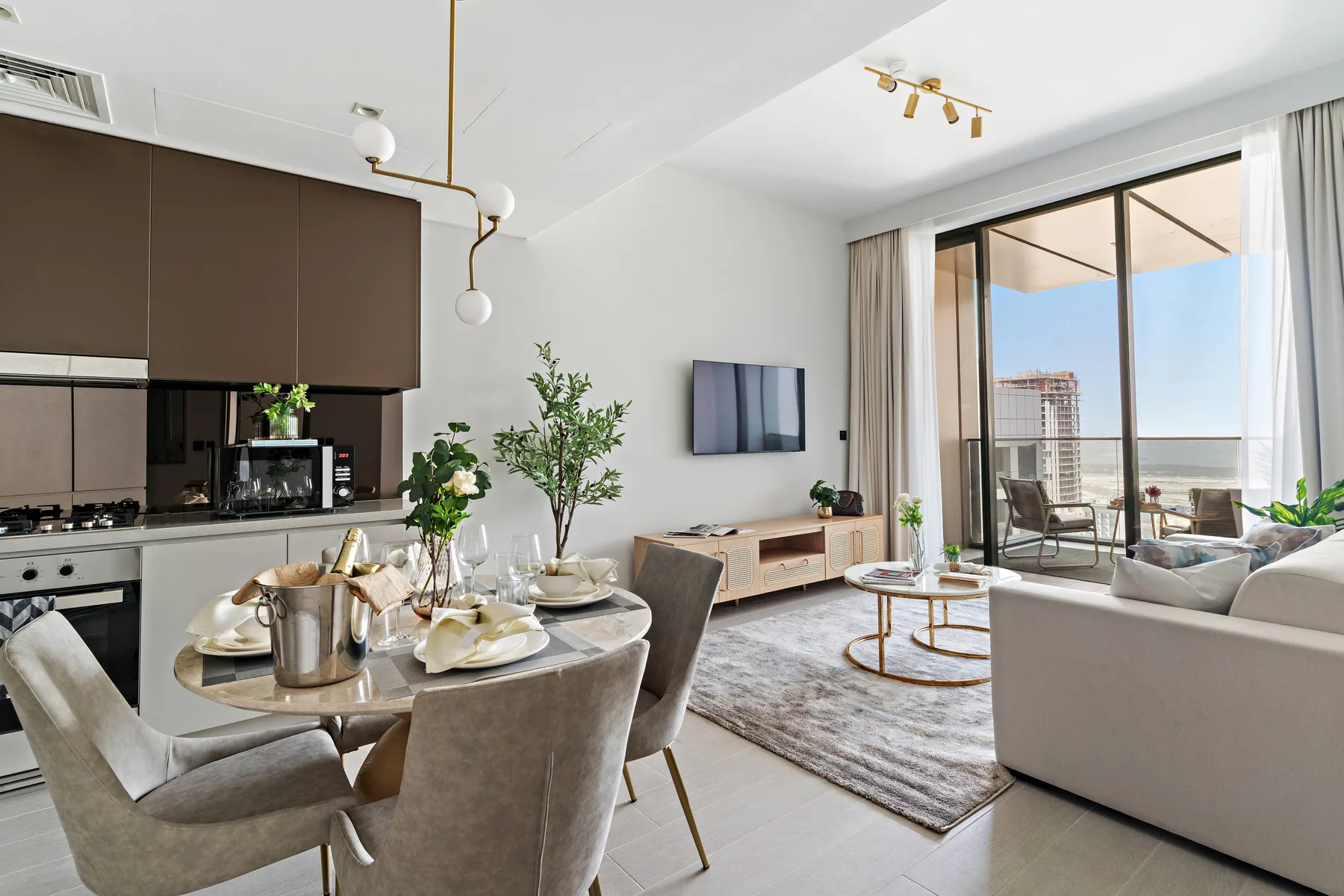 Una sala de estar y cocina de planta abierta con comedor junto a grandes puertas de vidrio.