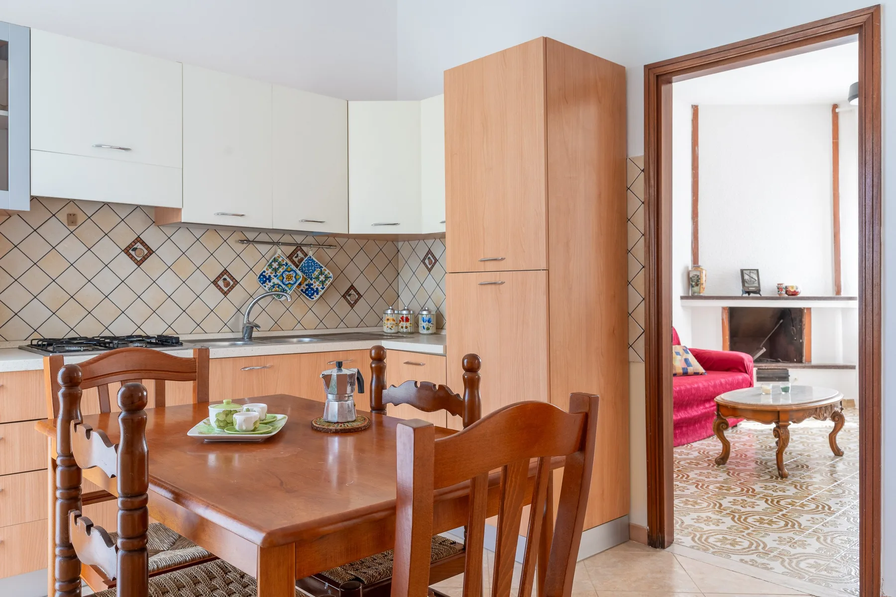 Comedor con una mesa de madera junto a una cocina.