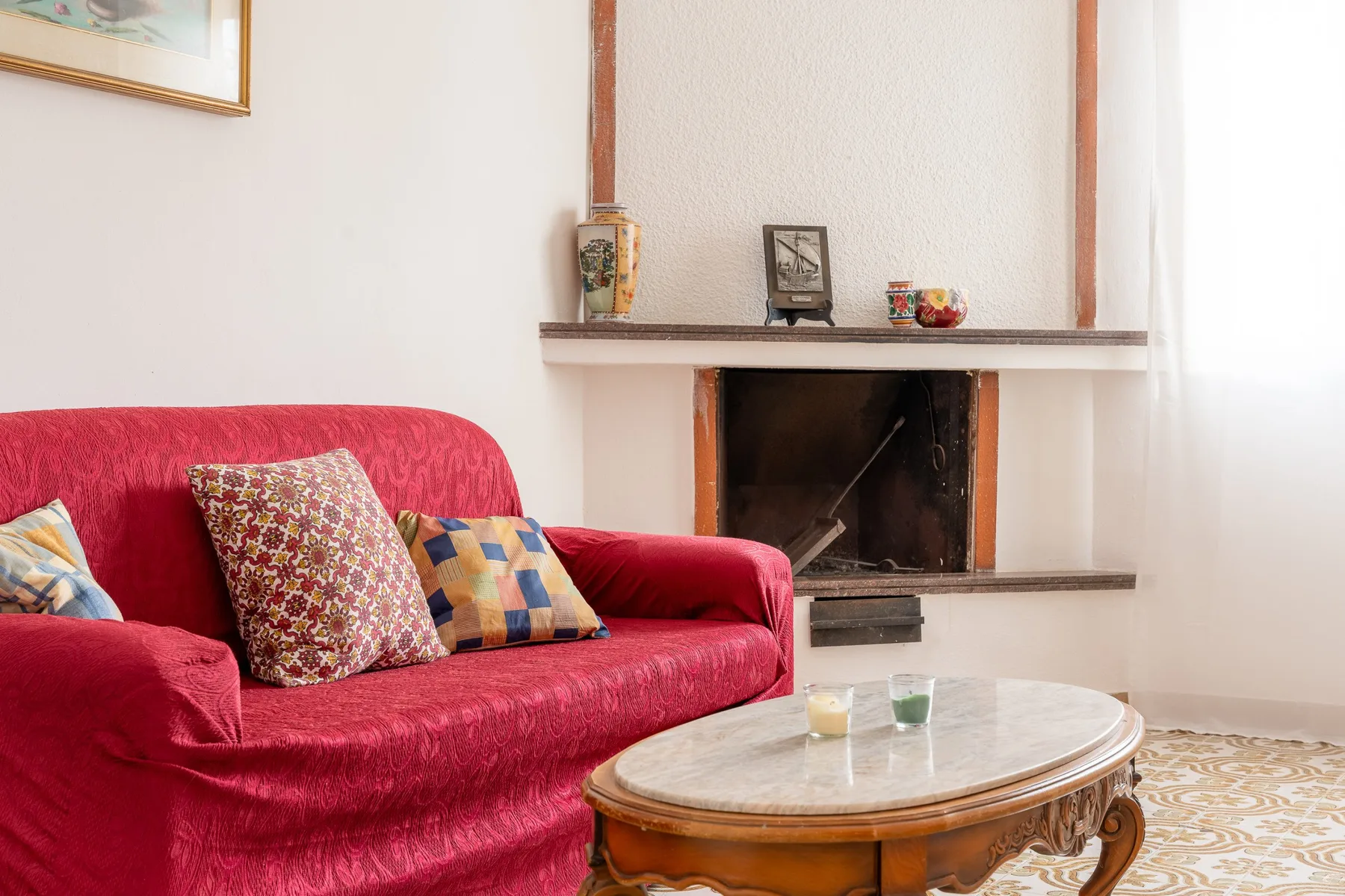 Una sala de estar con asientos rojos, una chimenea y una mesa de centro baja.