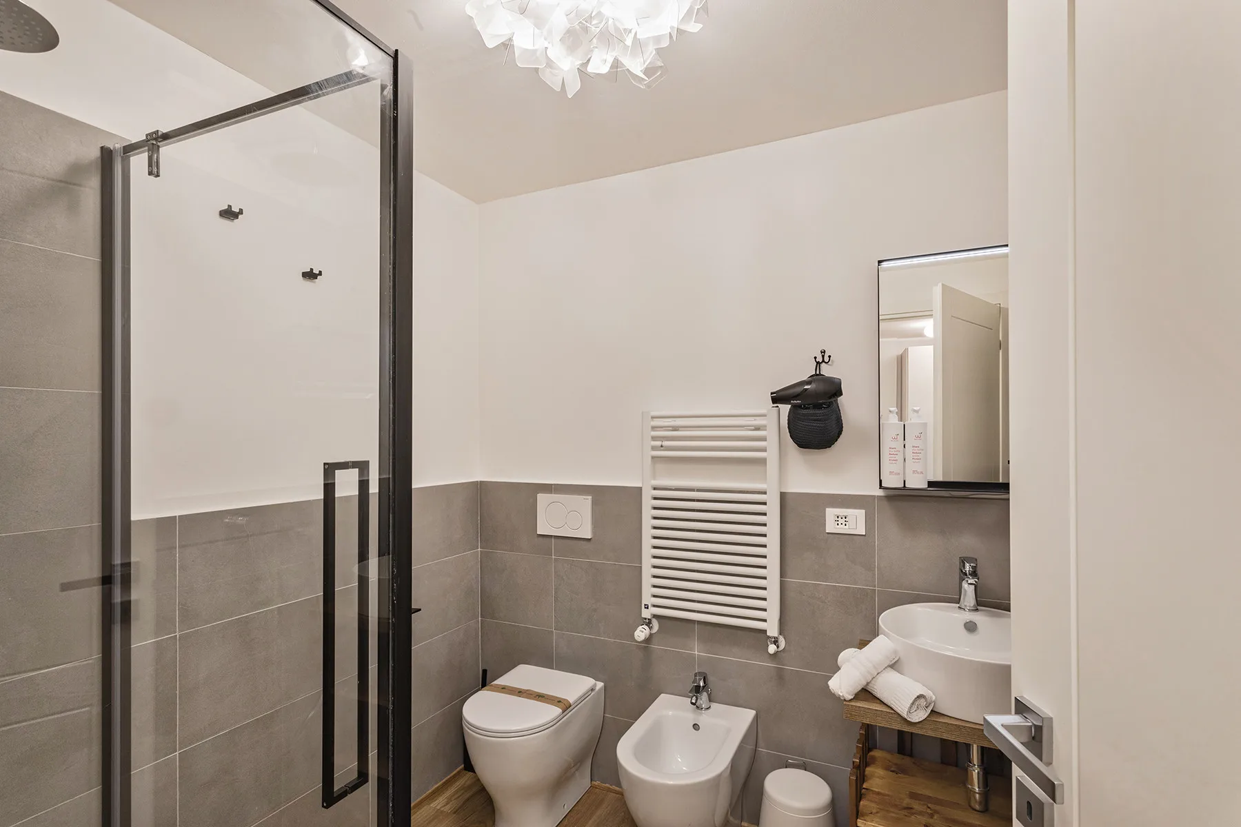 Un baño con ducha de vidrio, inodoro y lavabo.