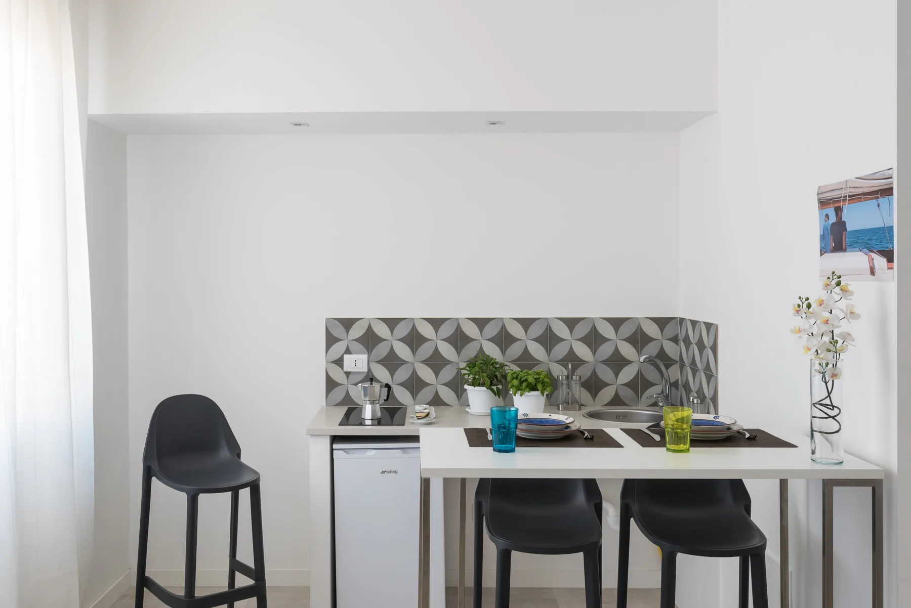 Un comedor con una mesa, asientos y un salpicadero estampado.