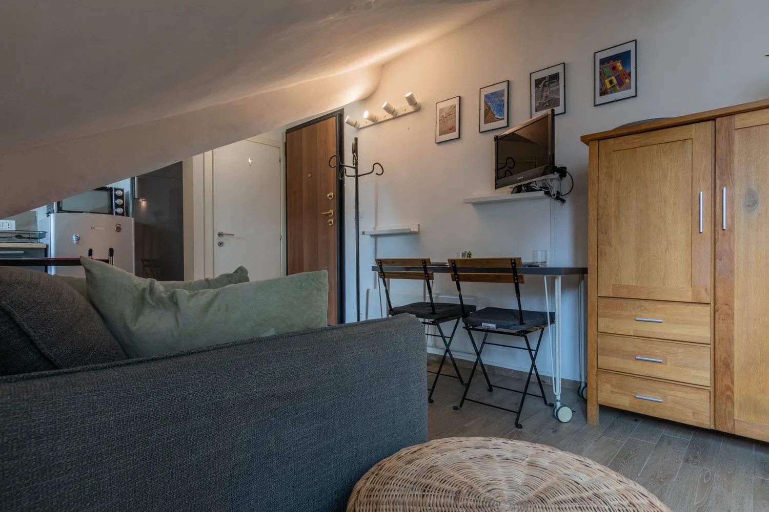 A compact living and dining area with seating, a table, and a television.