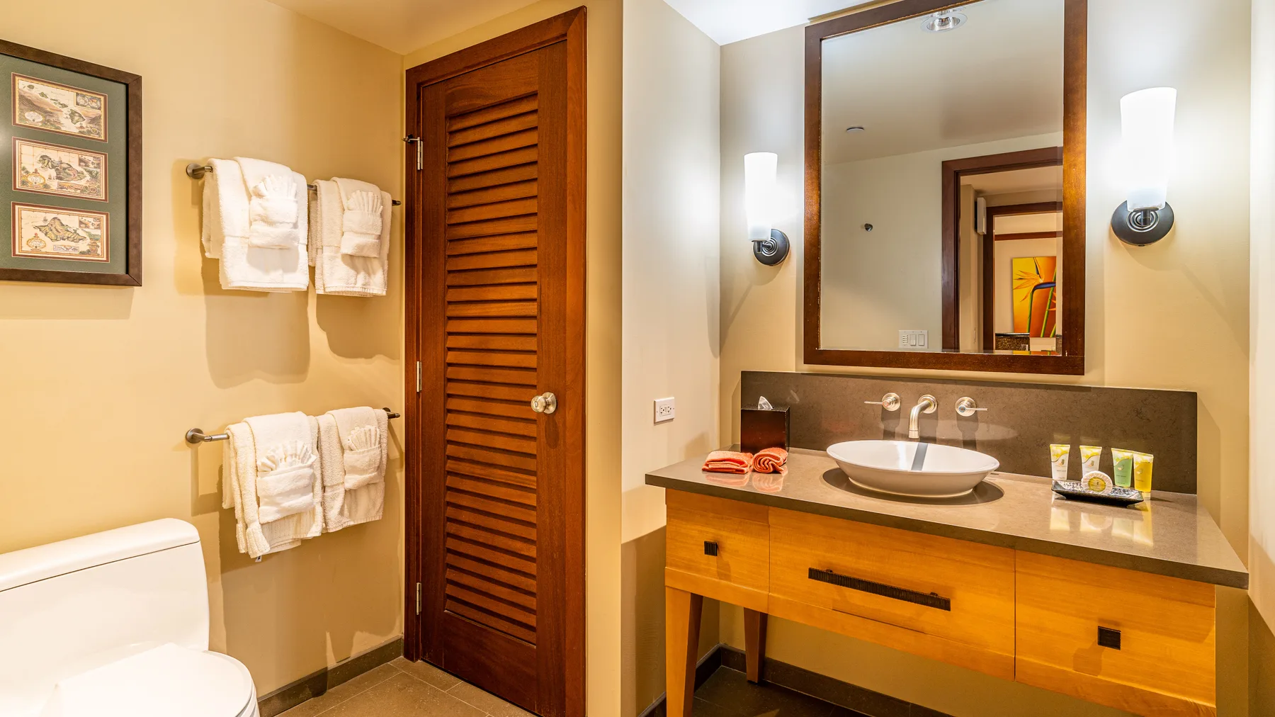 Un lavabo de baño con espejo junto a una puerta de madera con lamas.