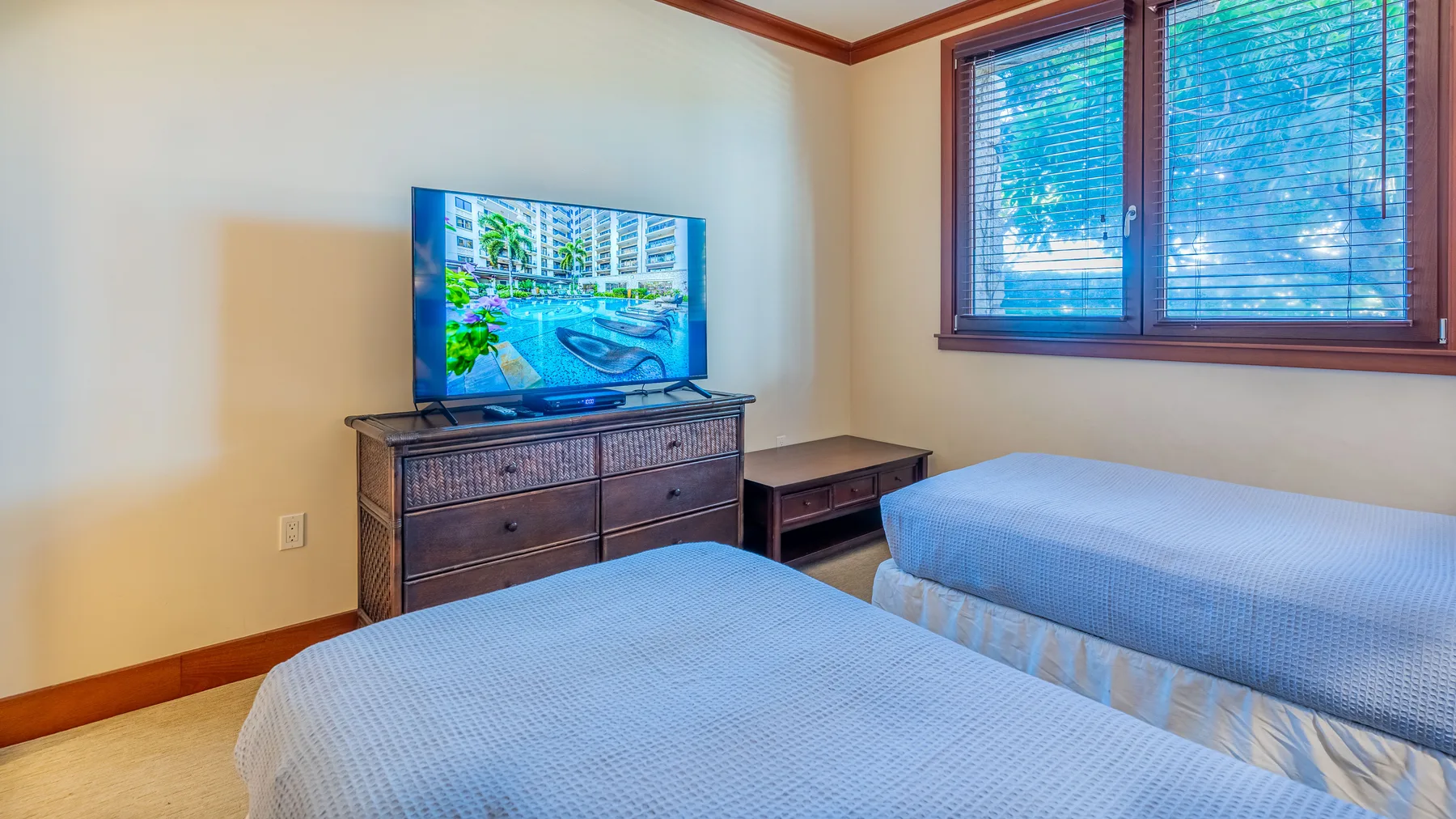 Un dormitorio con dos camas, un televisor y una ventana con persianas.