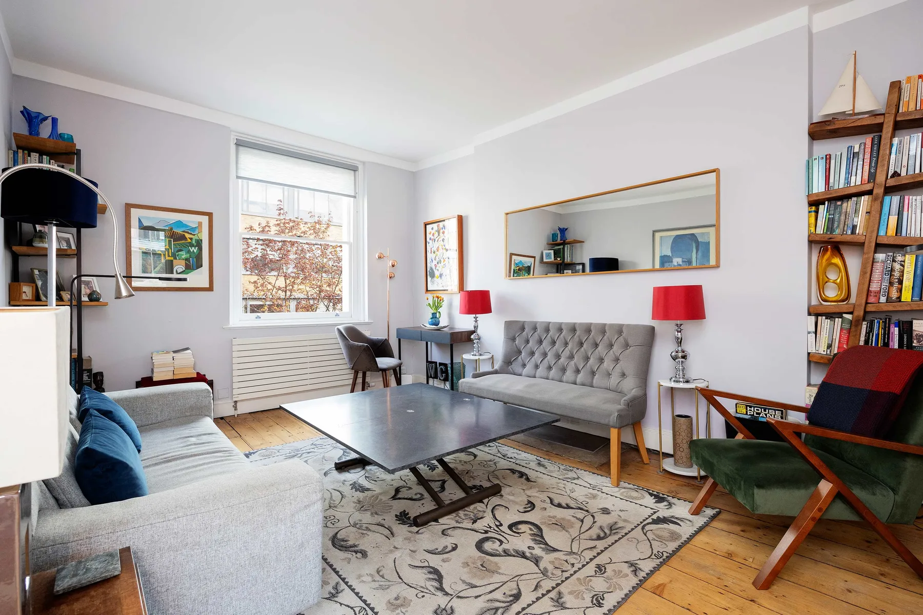 A living room with seating around a coffee table and a large window.
