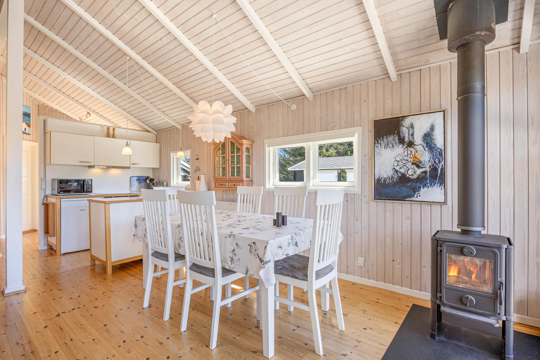 Comedor con una mesa y sillas junto a una cocina abierta.