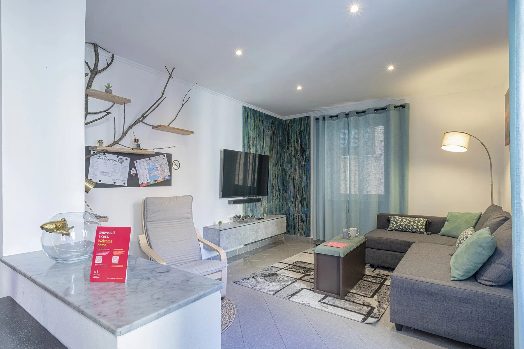 Una sala de estar con asientos, un televisor y cortinas azules.