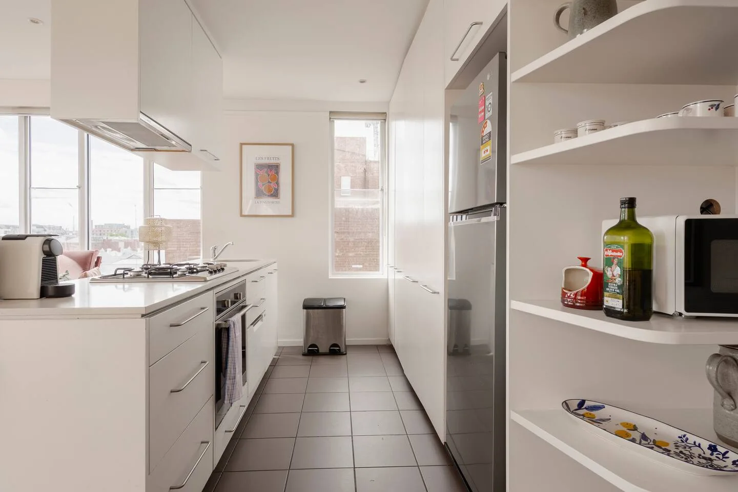 A bright kitchen with a countertop and open shelves.