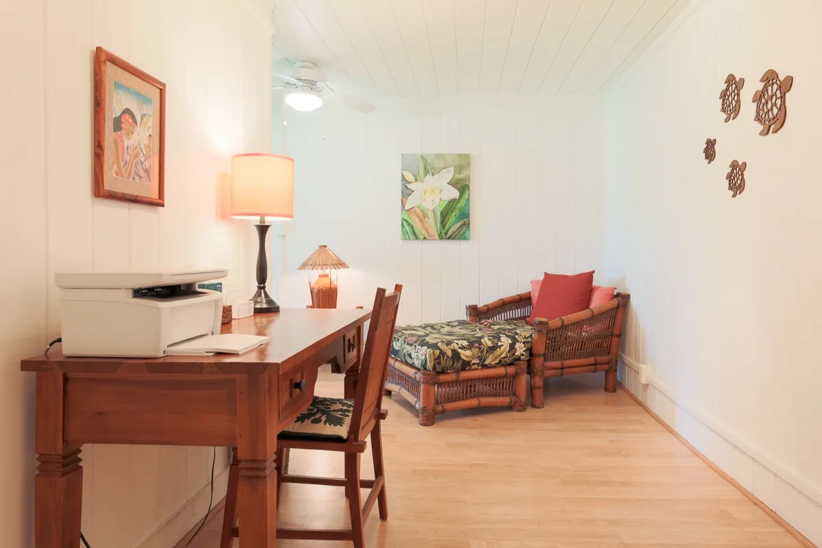 A bright room with a wooden desk and a daybed along the wall.