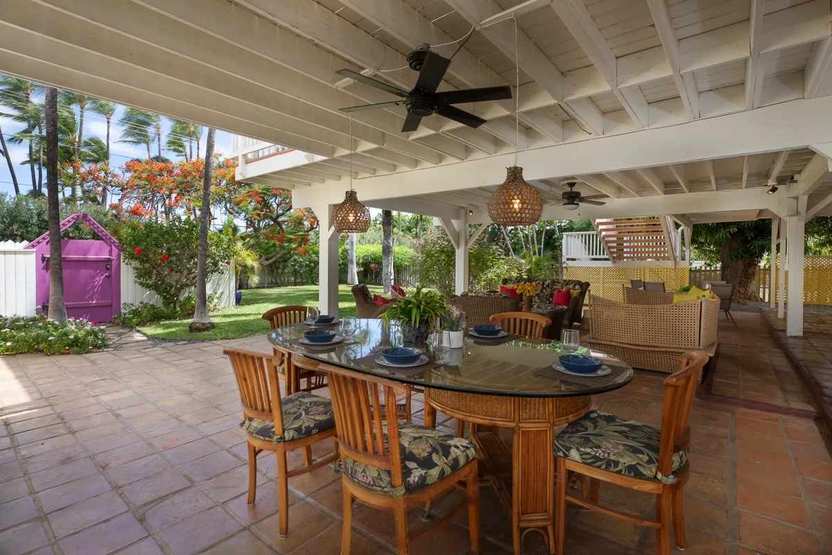 A covered outdoor dining area with a table and seating.
