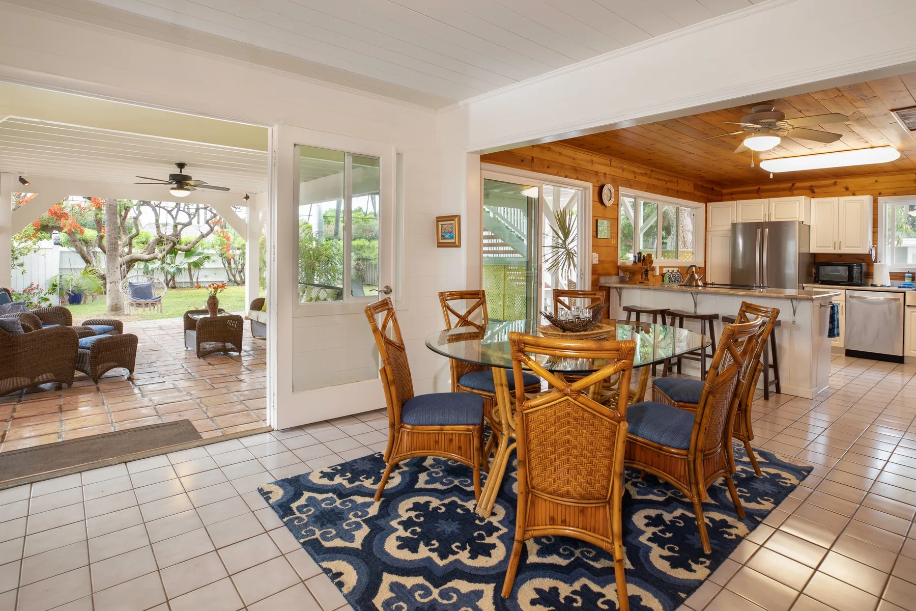 A dining area with a glass-topped table and chairs beside the kitchen.