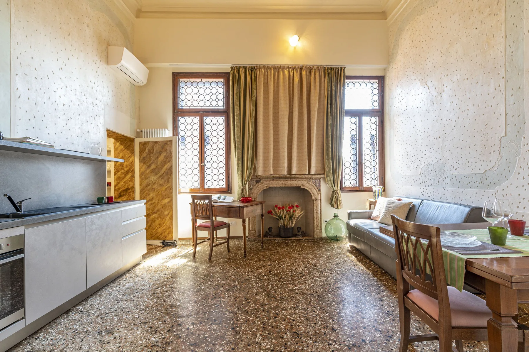 Una cocina integrada con sala de estar y una mesa de comedor junto a las ventanas.