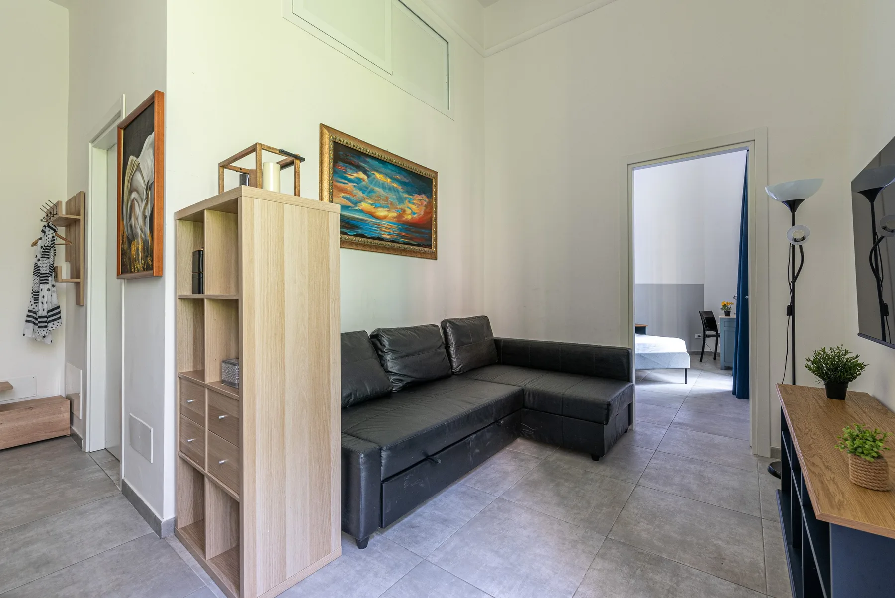 A living room with an L-shaped seating area and framed artwork.