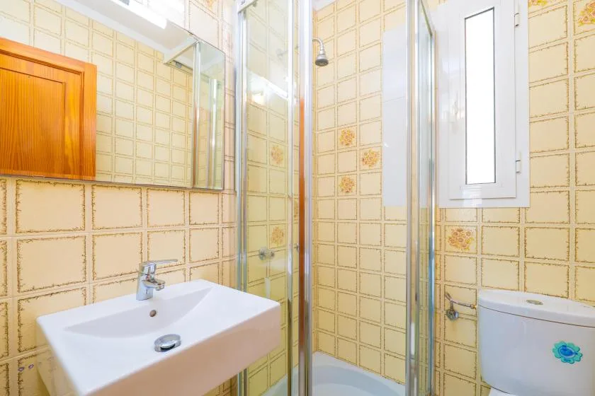 A tiled bathroom with a sink, shower, and toilet.