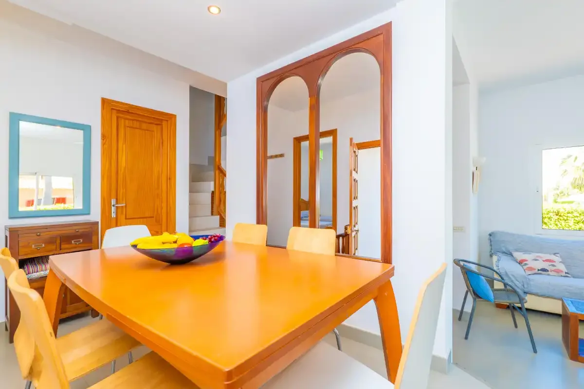 A dining area with a large wooden table beside an adjoining sitting area.