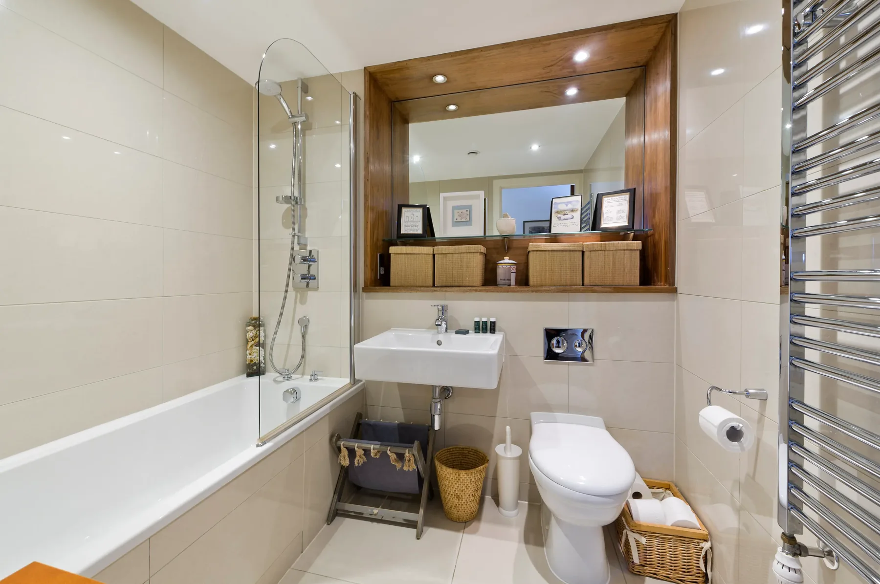 Un baño luminoso con bañera, lavabo e inodoro.