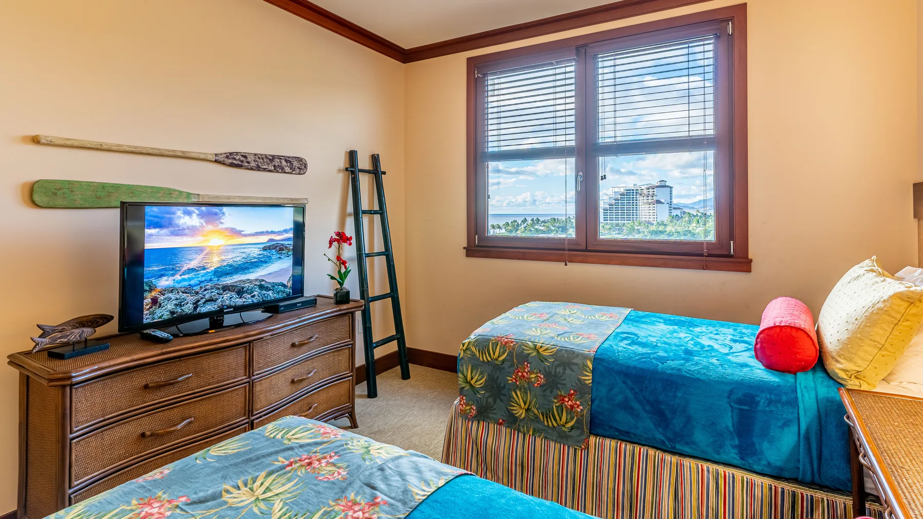 Un dormitorio con dos camas, un televisor y una ventana con persianas.