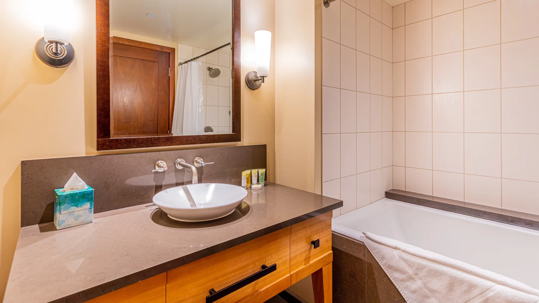 Un baño con lavabo, espejo y bañera.