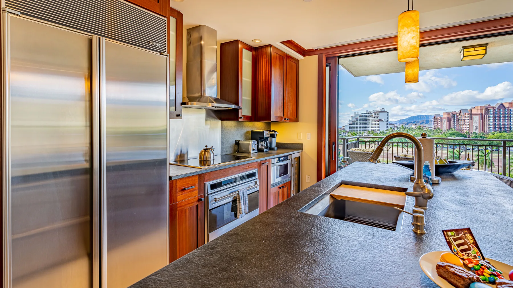 Una cocina moderna con una isla grande y vistas a edificios cercanos.