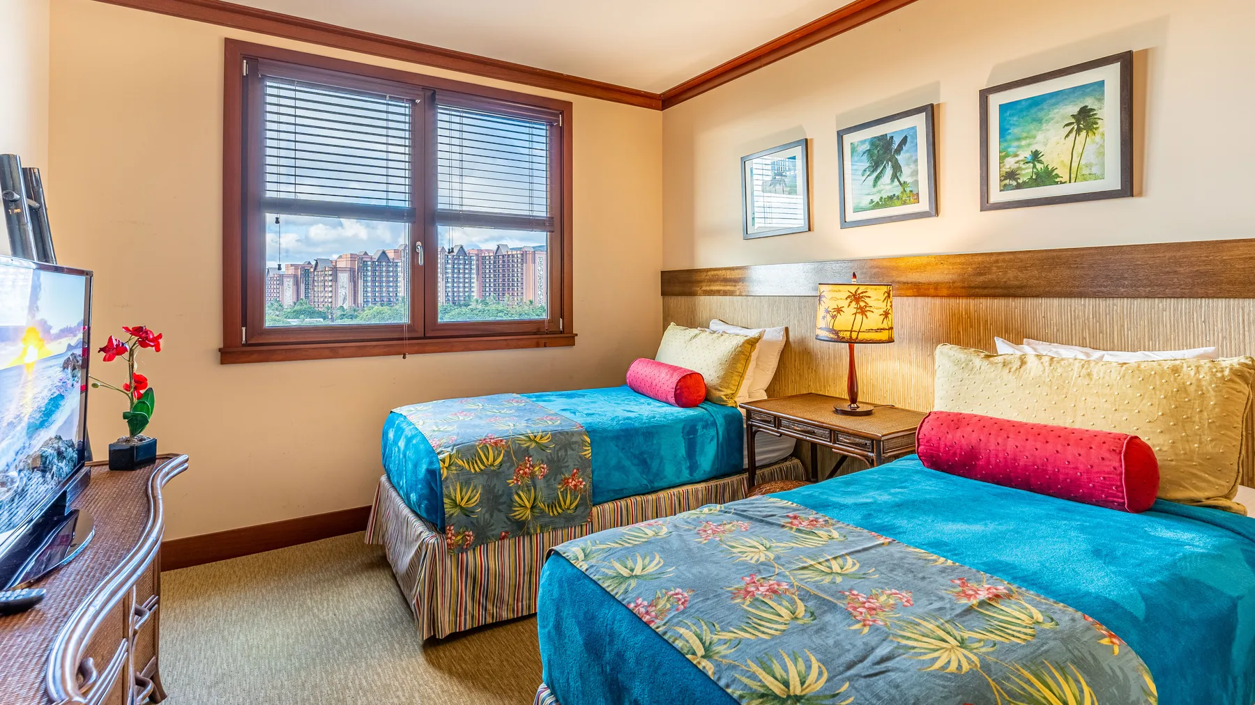 Un dormitorio con dos camas cubiertas con ropa de cama azul brillante y una ventana.