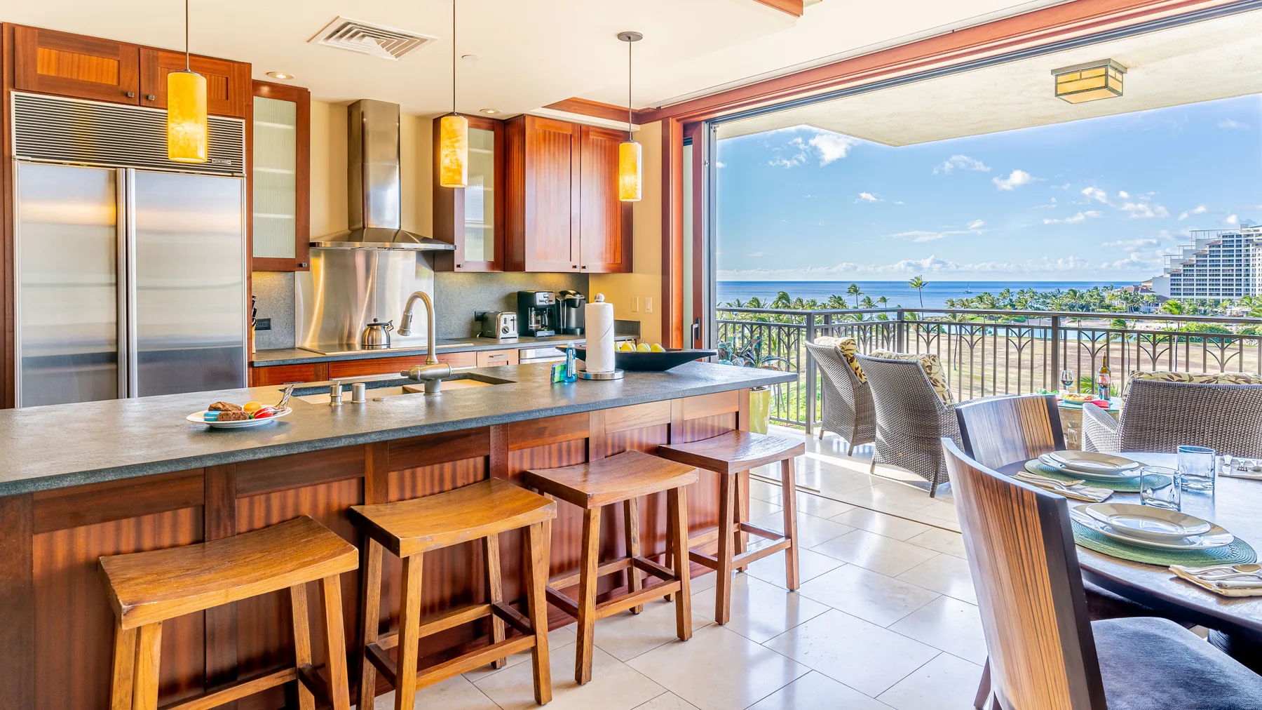 Una cocina abierta y zona de comedor dan a un balcón con vistas al mar.