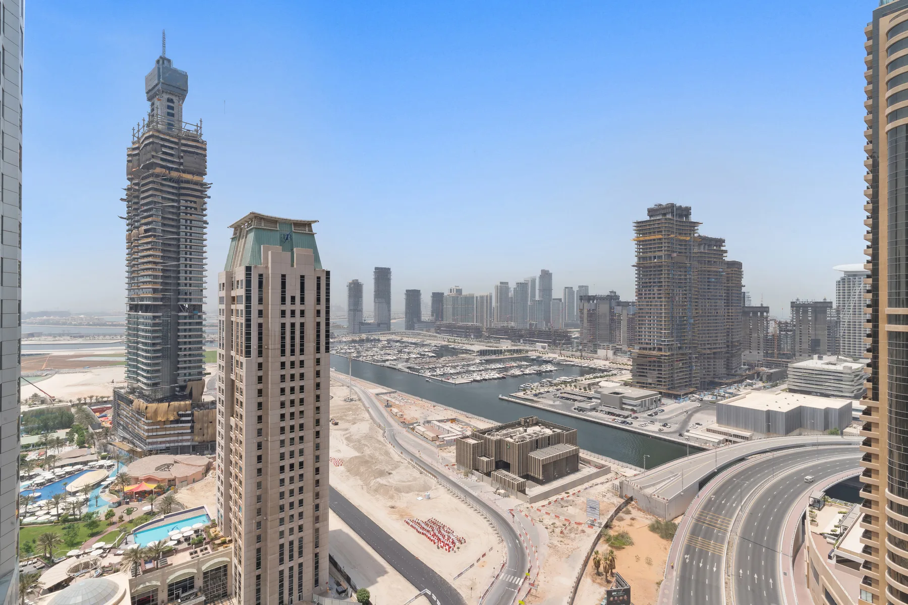 A city skyline and curving roads are visible from an elevated viewpoint.