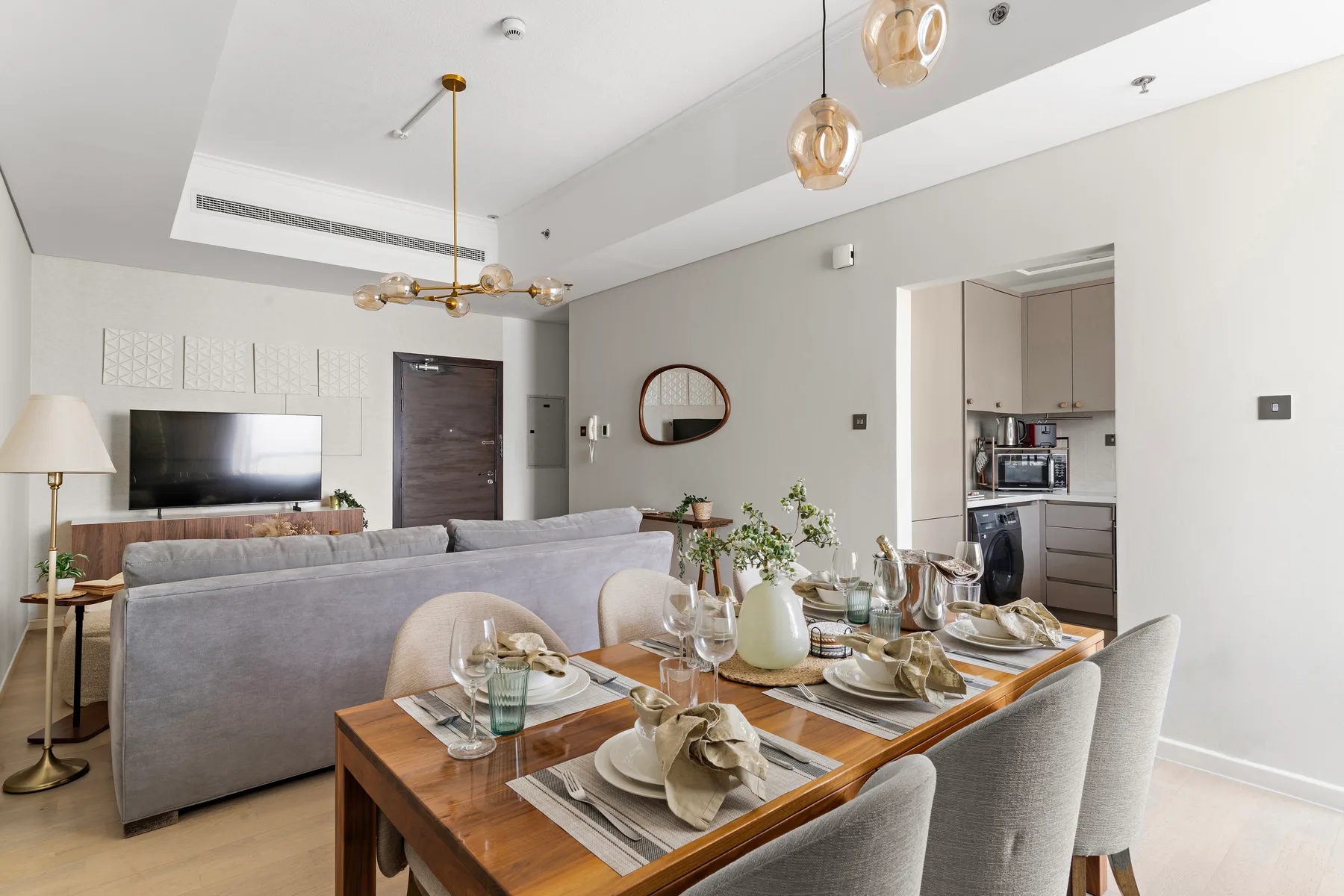 Una luminosa sala de estar y comedor tiene una mesa junto a la zona de asientos.
