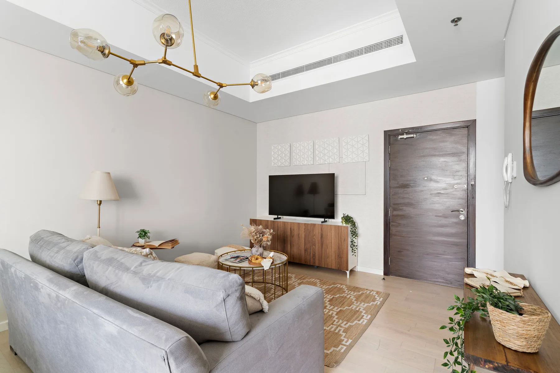 Una sala de estar moderna con asientos, un televisor y un mueble de madera.