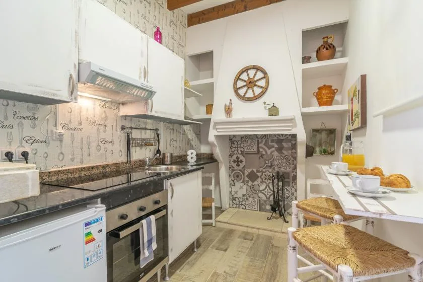 A bright kitchen and dining area with patterned tile around the fireplace.