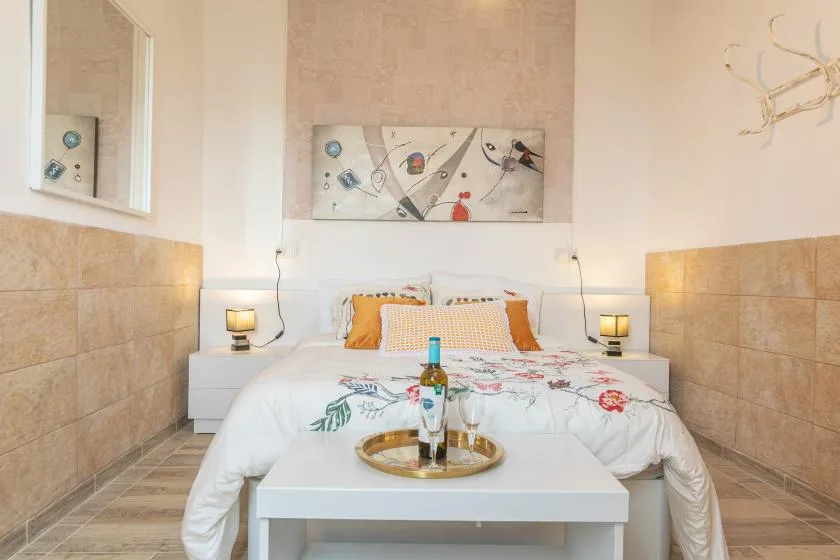 A bedroom with a bed, bedside tables, and a small table at the foot.