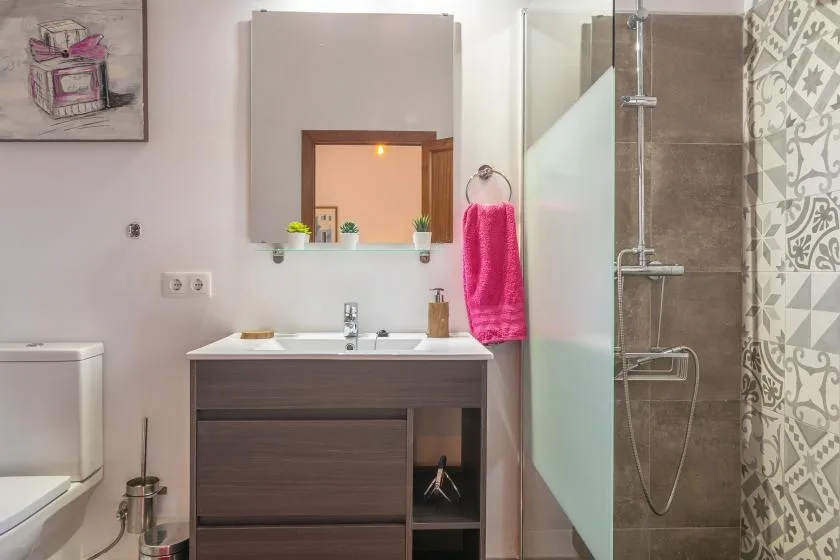 A bathroom with a vanity sink, mirror, and glass shower.