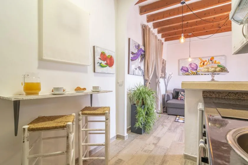 A compact open-plan living area with a small dining counter and gray seating.