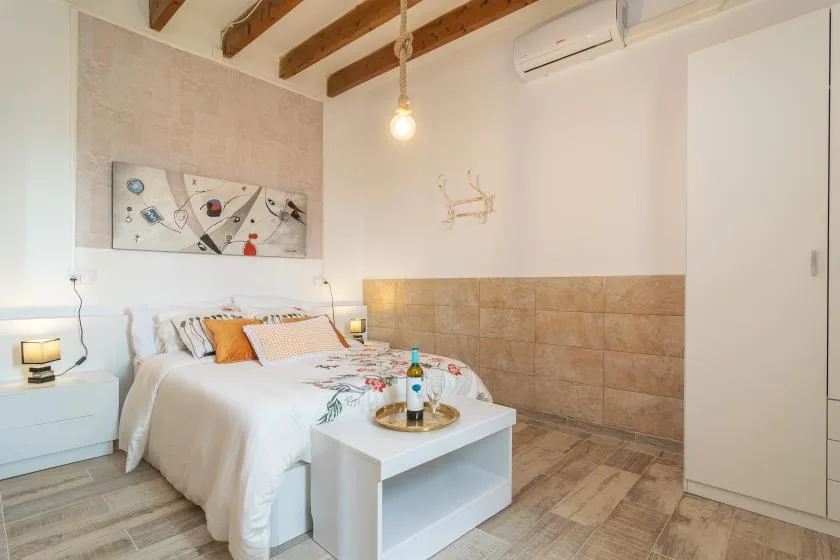 A bedroom with a bed, bedside tables, and a small table at the foot.