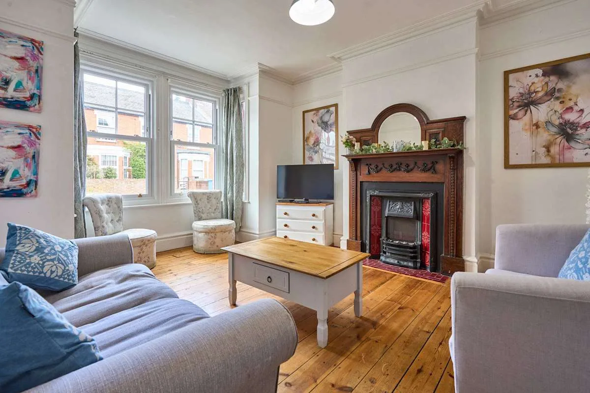 A living room with seating, a television, and a decorative fireplace.