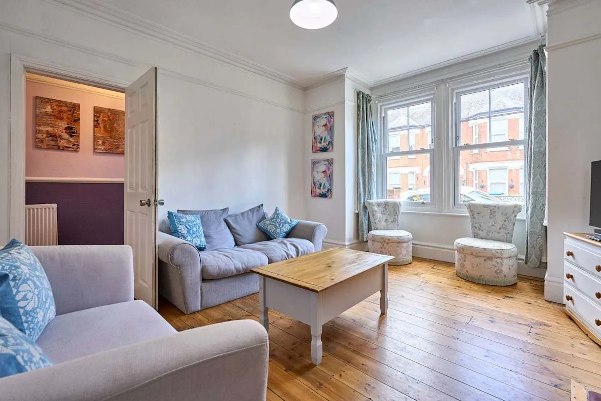 A living room with seating, a coffee table, and large windows.