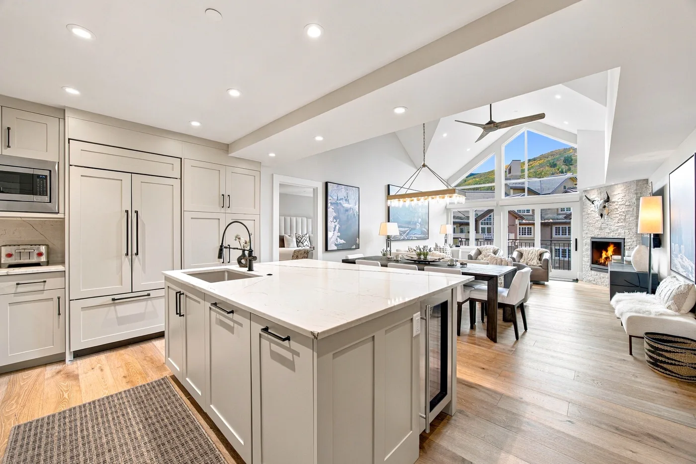 A bright open-plan kitchen and living area, with a large island and expansive windows.