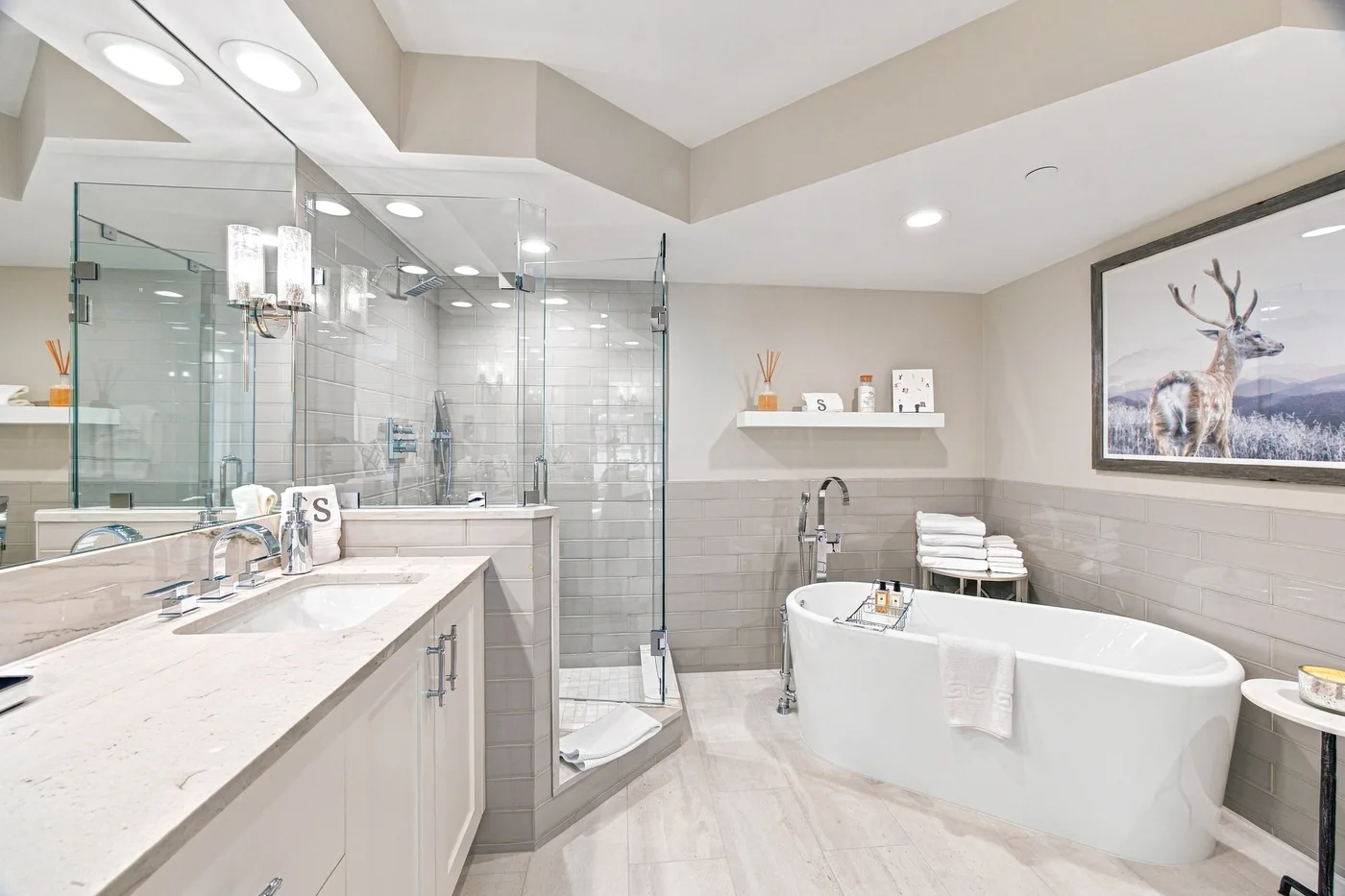 A bright bathroom features a freestanding bathtub, glass shower, and long vanity.