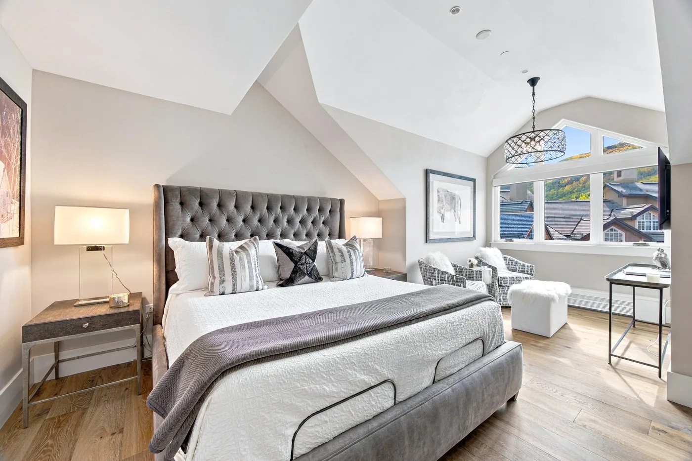 A bright bedroom with a large bed and windows overlooking the outdoors.