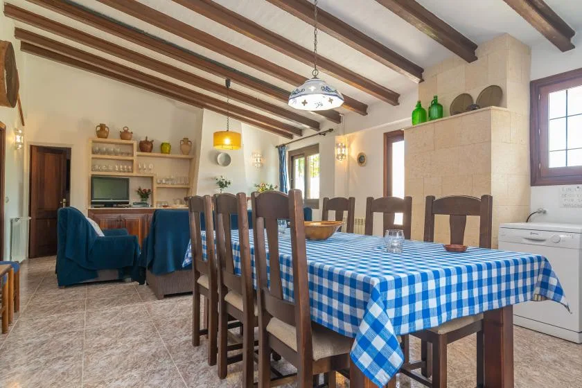 Comedor con una mesa larga cubierta con un mantel de cuadros azules y blancos.