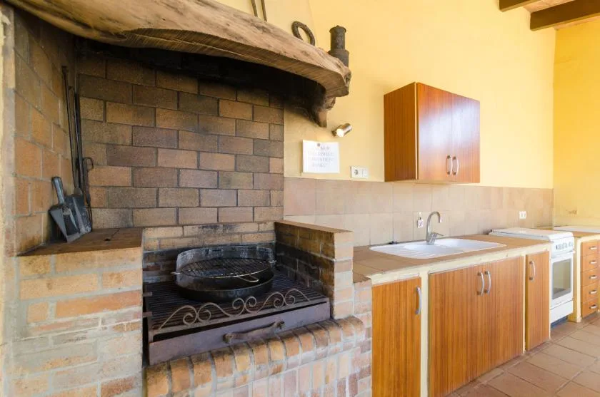 Una cocina con un hogar de ladrillo y una encimera con fregadero.