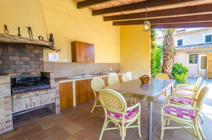 Una zona de comedor exterior cubierta con una mesa larga y asientos de mimbre.