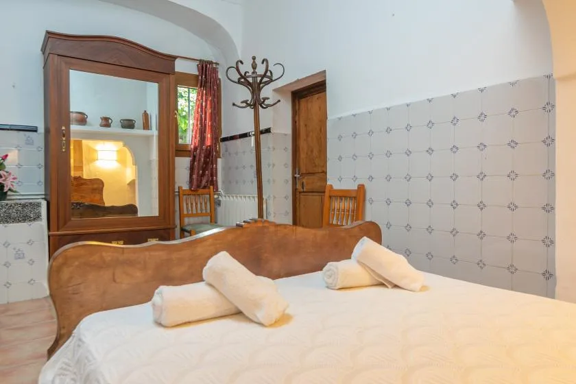 Un dormitorio con una cama grande, muebles de madera y paredes de azulejos estampados.
