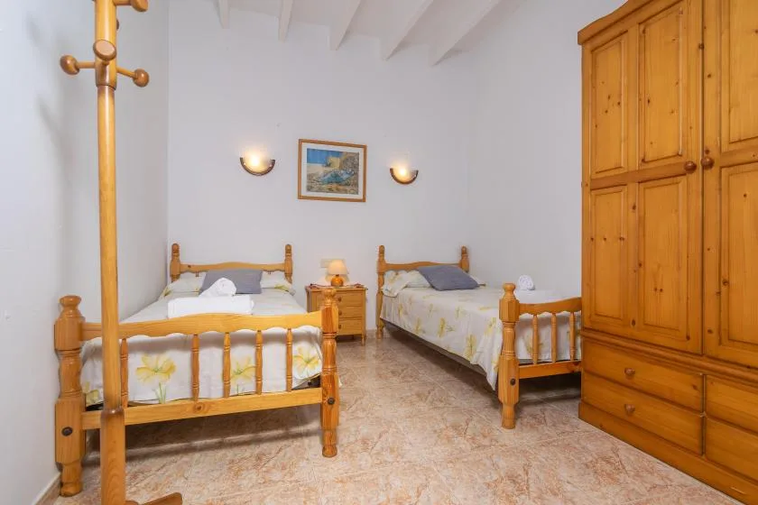 Un dormitorio con dos camas de madera y un armario grande.