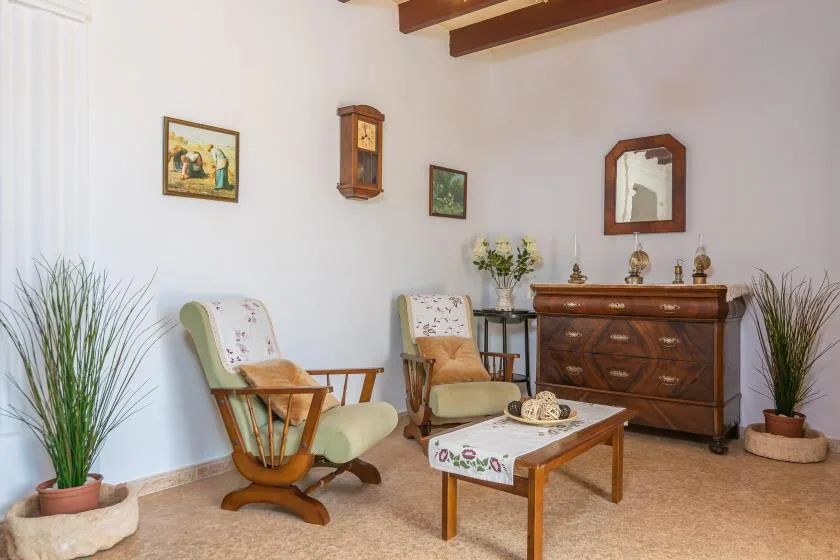 Una sala de estar con dos asientos acolchados y una mesa de centro de madera.